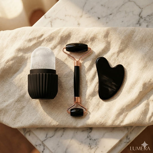 Black and rose gold facial tools on a marble surface with 'LUMERA' branding.